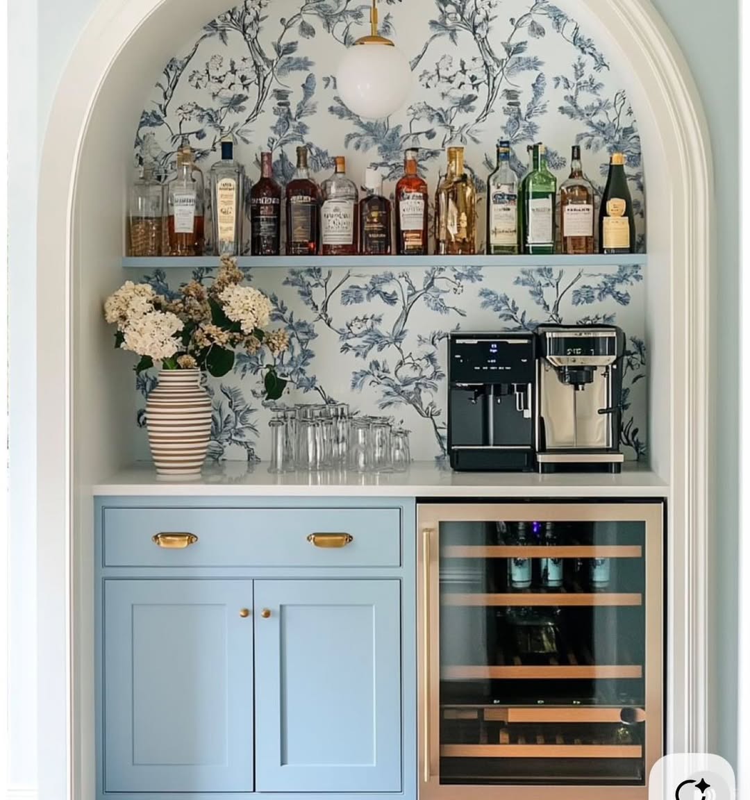 Arched alcove with blue toile wallpaper, light blue cabinets and a coffee machine