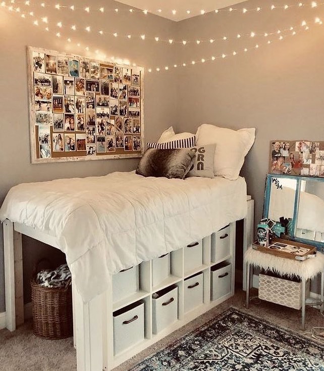 Lofted dorm bed above a white cube shelf filled with storage bins