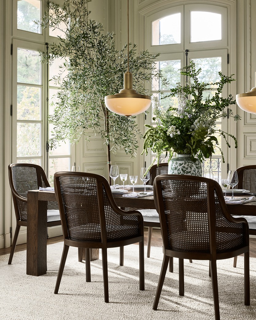 Green hydrangeas and eucalyptus in ceramic vases on a rustic wood farmhouse dining table