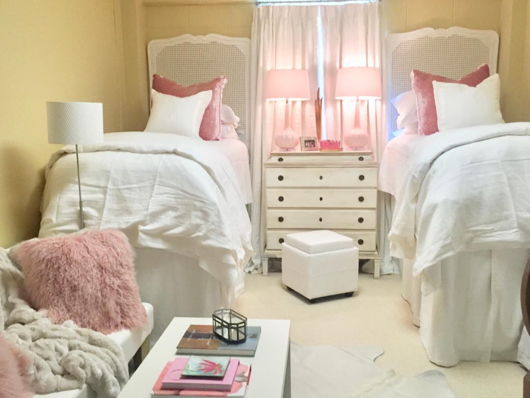 Two twin beds with cane headboards and pink accents against warm yellow walls