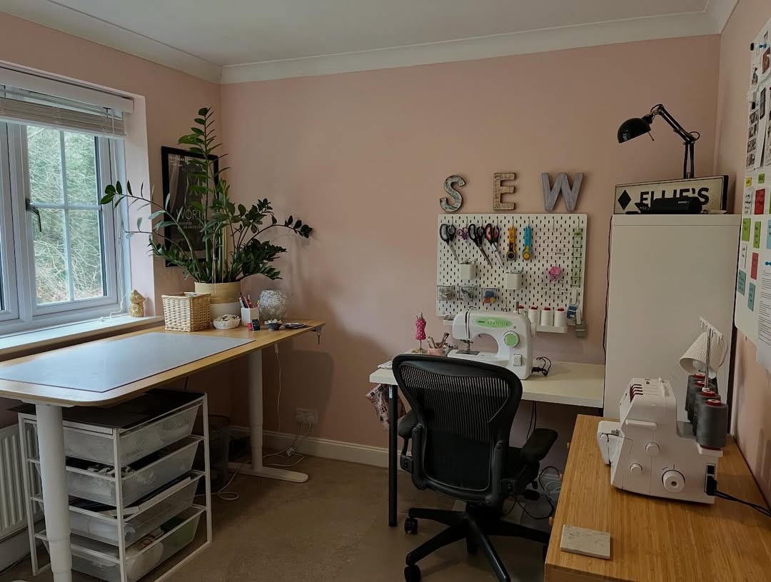Pink sewing corner with a SEW letter sign above a pegboard