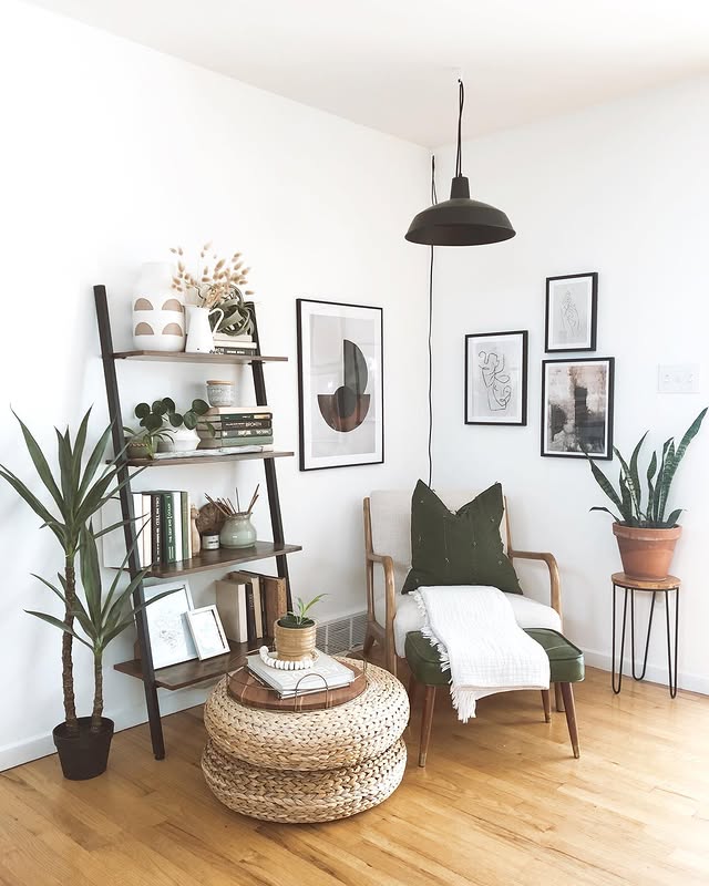 Four black framed line art prints stepping around a corner above a mid century reading chair