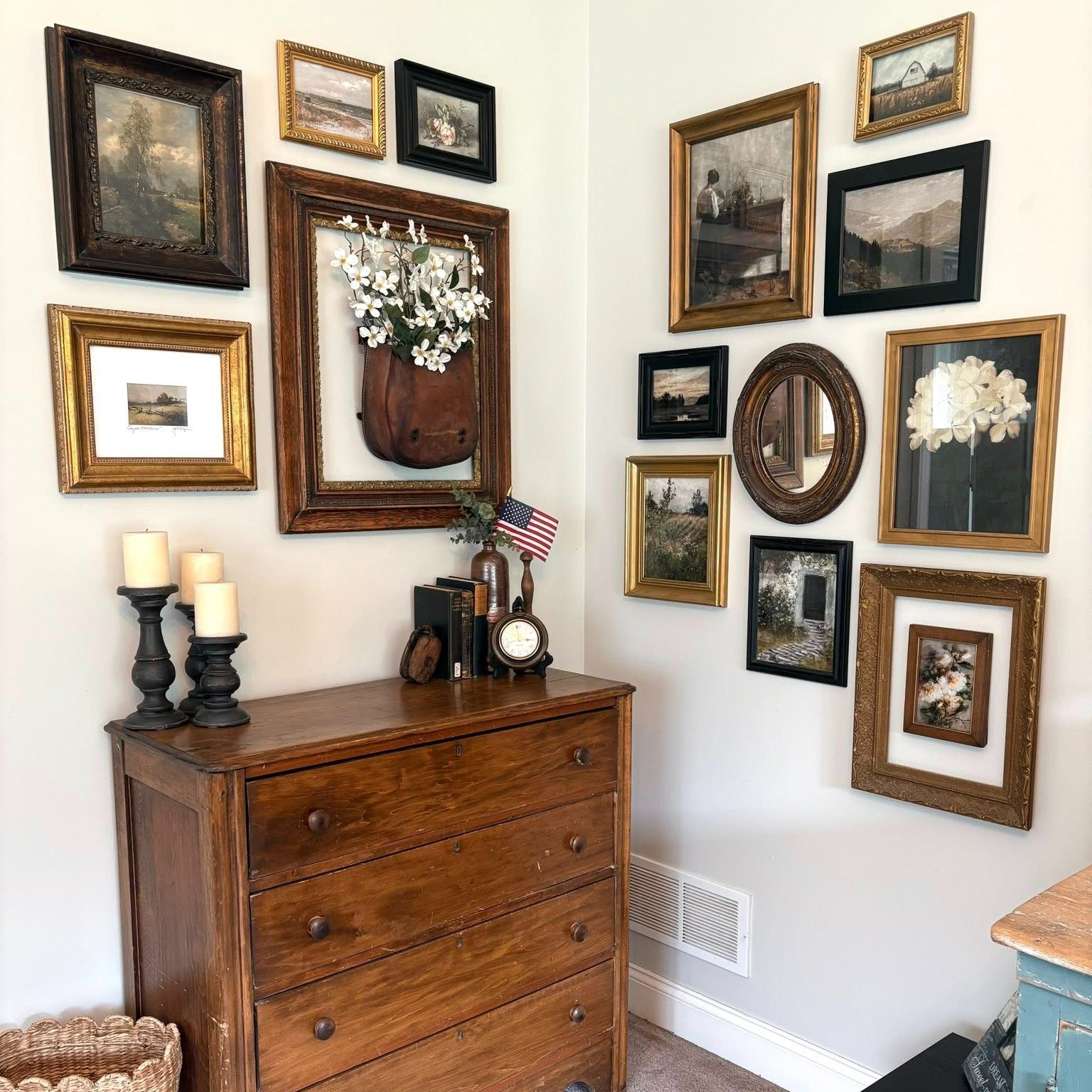 Vintage gold and black frames wrapping a corner above an antique wood dresser