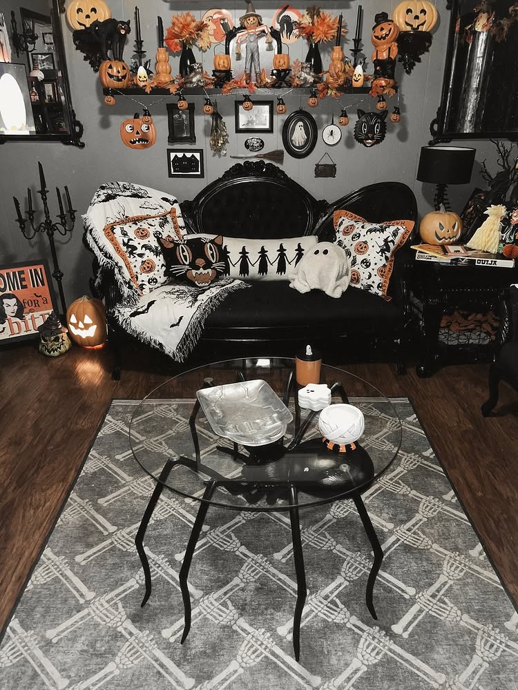 Vintage Halloween living room with black settee, orange pumpkins and skeleton hand rug